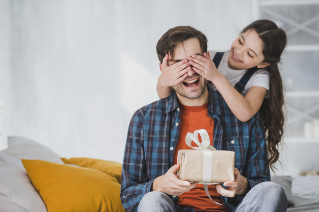 fathers-day-concept-with-daughter-covering-fathers-eyes_23-2147805571